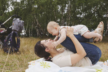 Mother playing with cute girl in park - IHF01219