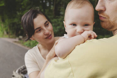 Mother and father with baby girl in park - IHF01220