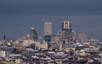 Luftaufnahme eines dicht bebauten Stadtteils von Madrid mit modernen Wolkenkratzern zwischen Häusern mit roten Dächern und historischen Gebäuden - ADSF37821