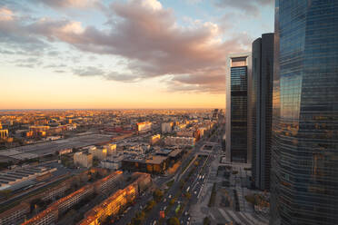 From above of modern district of Madrid with skyscrapers in evening sunlight under beautiful sky with clouds - ADSF37829