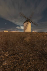 Old traditional windmills located in countryside field on starry night - ADSF37919