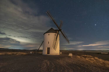 Old traditional windmills located in countryside field on starry night - ADSF37920
