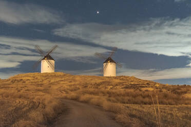 Old traditional windmills located in countryside field on starry night - ADSF37921