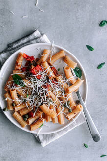 Draufsicht auf das köstliche Gericht Makkaroni Pasta alla Puttanesca über Gray Rustic Table - ADSF37924
