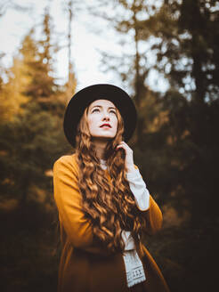 Porträt einer schönen jungen Frau, die einen Hut trägt und auf dem Lande steht - ADSF37957