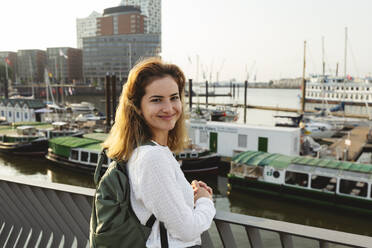 Smiling woman standing at Port of Hamburg, Germany - IHF01228