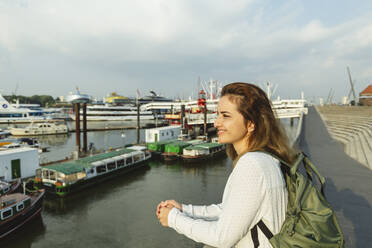 Happy woman standing by railing at Port of Hamburg, Germany - IHF01231