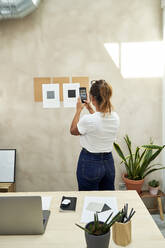 Freiberufler, der ein Bild von der Geschäftsstrategie an der Wand im Heimbüro macht - VEGF05948