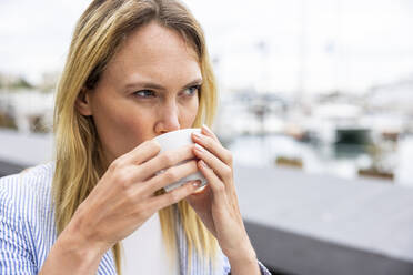 Businesswoman with blond hair drinking coffee - WPEF06375