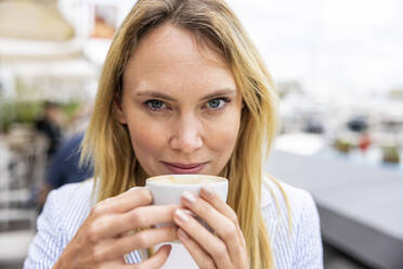 Lächelnde blonde Geschäftsfrau mit Kaffeetasse - WPEF06376