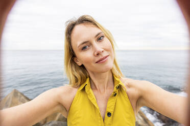 Schöne blonde Frau nimmt Selfie vor dem Meer - WPEF06397