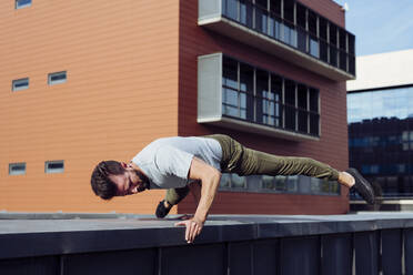 Sportlicher Mann bei Parkour-Übungen im Freien - ADSF38072