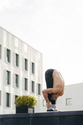 Sportlicher Mann macht Parkour-Gleichgewichtsübungen im Freien in einer städtischen Szene - ADSF38075