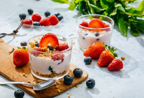 Von oben köstlichen hausgemachten Joghurt mit Erdbeeren, Beeren und Getreide auf weißem Hintergrund - ADSF38263