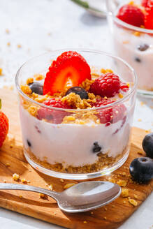 Nahaufnahme von leckeren hausgemachten Joghurt mit Erdbeeren, Beeren und Getreide auf weißem Hintergrund - ADSF38265