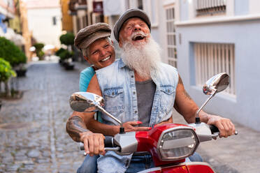 Frontansicht eines modernen älteren Paares auf einem Motorrad während der Fahrt durch die Stadt - ADSF38284