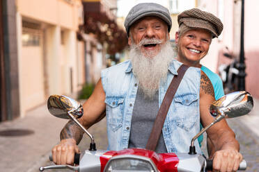 Frontansicht eines modernen älteren Paares auf einem Motorrad während der Fahrt durch die Stadt - ADSF38293
