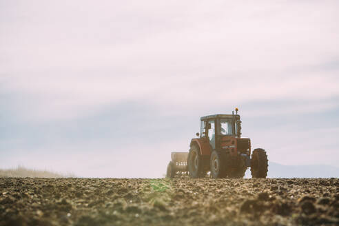 Alter Traktor bei der Arbeit auf dem Feld - ADSF38436