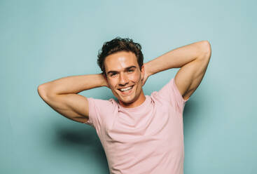 Junger fröhlicher Mann im T-Shirt mit braunem Haar und zahnigem Lächeln - ADSF38614