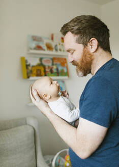 Father holding newborn son (0-1 months) at home - TETF01756