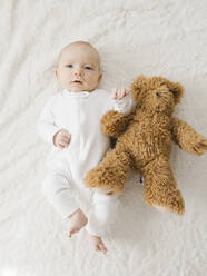 Baby-Junge (2-5 Monate) Junge liegend auf Bett mit Teddybär - TETF01763