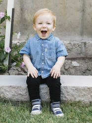 Porträt eines lächelnden Jungen (2-3), der im Freien sitzt - TETF01778