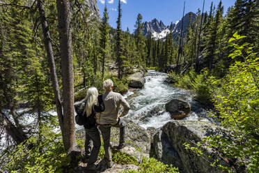 Vereinigte Staaten, Idaho, Stanley, Älteres Paar steht neben einem rauschenden Bach in der Nähe von Sun Valley - TETF01806