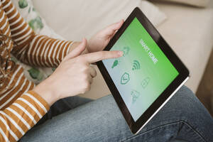 Close-up of woman using digital tablet with smart home app - EBBF06411