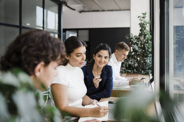 Businesswoman discussing strategy with colleagues in office - DCRF01360