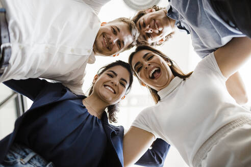 Happy business people huddling together in office - DCRF01369