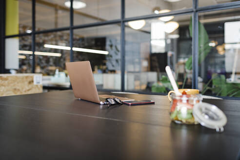 Laptop und Obst auf dem Tisch im Büro - DCRF01386