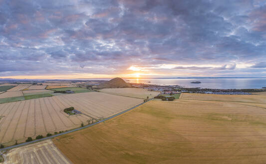 UK, Schottland, North Berwick, Luftaufnahme von Feldern vor der Küstenstadt bei bewölktem Sommer-Sonnenuntergang - SMAF02217