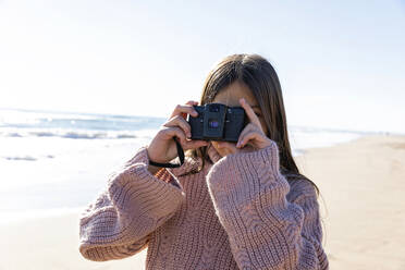 Mädchen mit Kamera, das am Strand fotografiert - MEGF00073