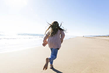 Girl running at beach on sunny day - MEGF00076