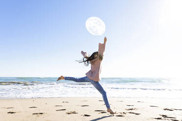 Mädchen springt mit Luftballon am Strand - MEGF00081