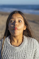 Mädchen mit Pullover macht Gesicht an einem sonnigen Tag - MEGF00123