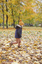 Junge in warmer Kleidung beim Spielen im Park - ONAF00027