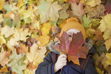 Junge bedeckt Gesicht mit Herbstblatt - ONAF00032