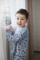 Niedlicher Junge, der zu Hause am Fenster steht - ONAF00073