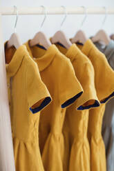 Gelbe Kleider auf Kleiderbügel hängend - ONAF00074