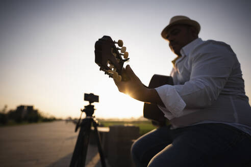 Gitarrist spielt Gitarre bei Sonnenuntergang - EKGF00114