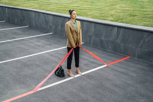 Businesswoman pulling red line at parking lot - VPIF07203