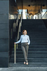 Selbstbewusste Geschäftsfrau mit Hand in der Tasche auf einer Treppe - VPIF07267