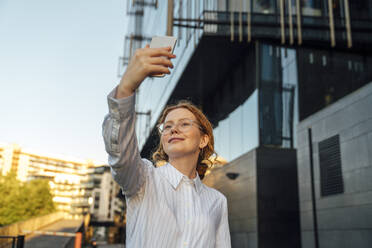 Smiling businesswoman taking selfie through smart phone - VPIF07281