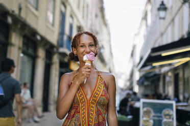 Lächelnde junge Frau leckt Eiscreme - DCRF01404