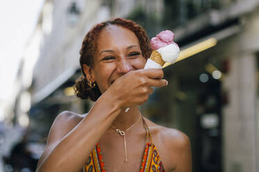 Fröhliche junge Frau genießt Eiscreme - DCRF01406