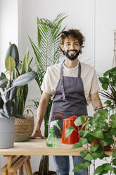 Lächelnder Mann vor einer Pflanze im Geschäft - XLGF03085