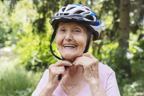 Smiling senior woman wearing bicycle helmet - OSF00942