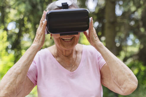 Lächelnde ältere Frau im Virtual-Reality-Simulator - OSF00945