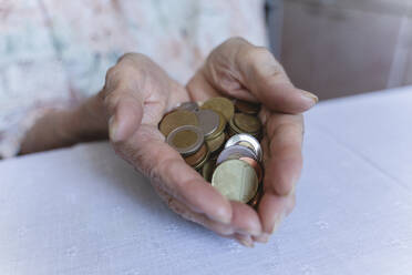 Coins in hands of senior woman at home - OSF00972